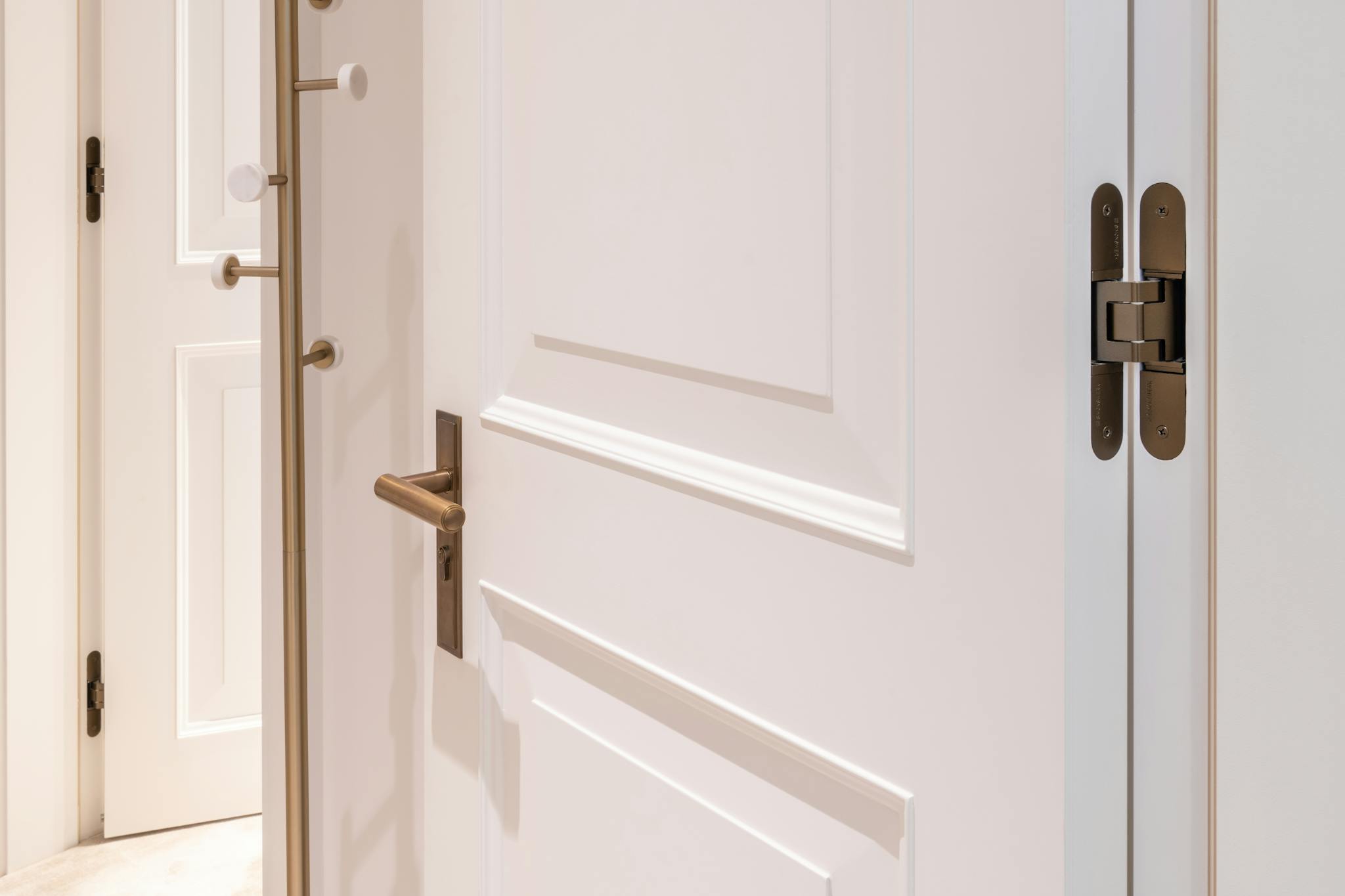 A fully open flush door showing the hinge and brass Joseph Giles hardware.